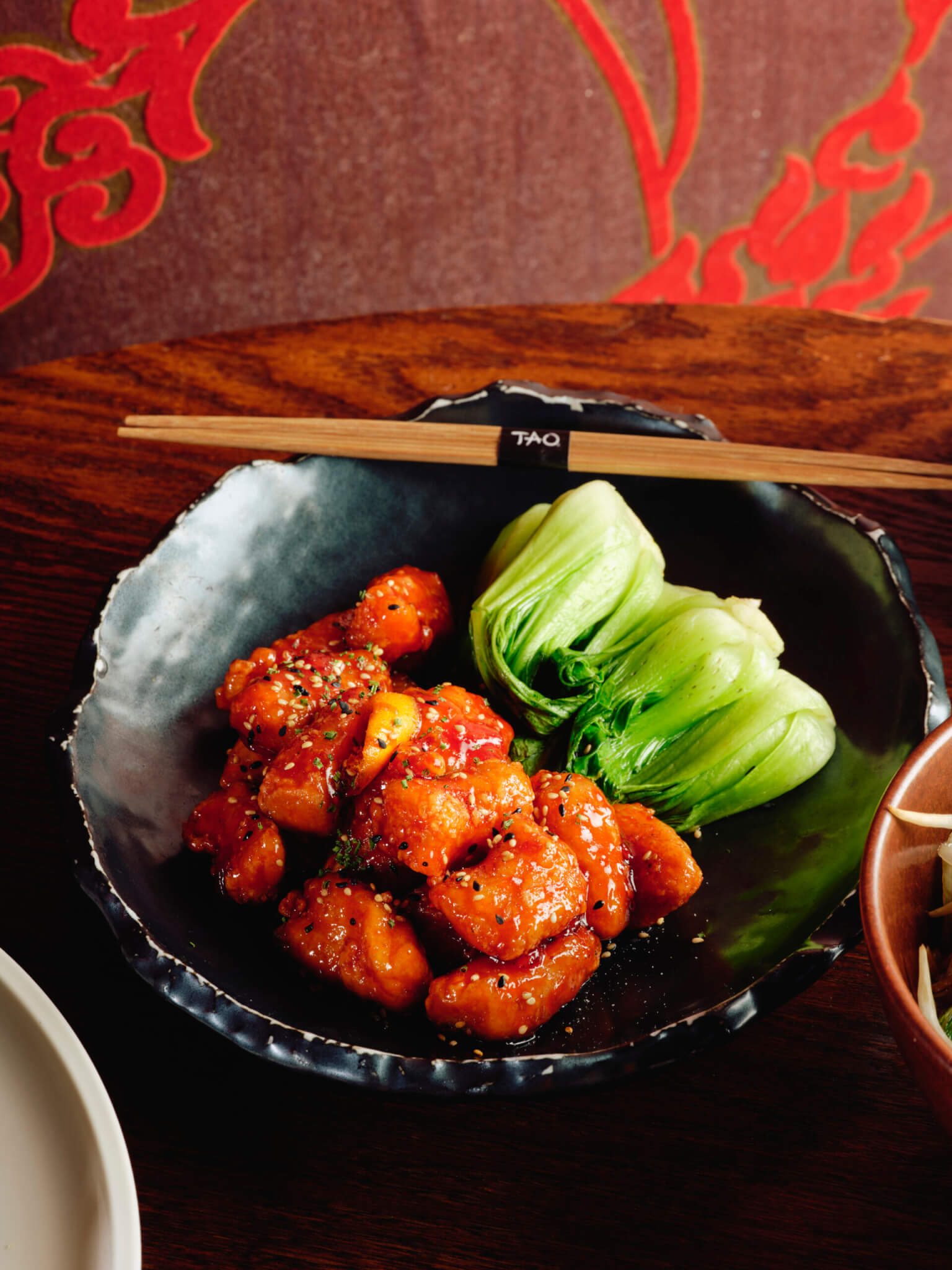 Bowl of orange chicken with bok choy