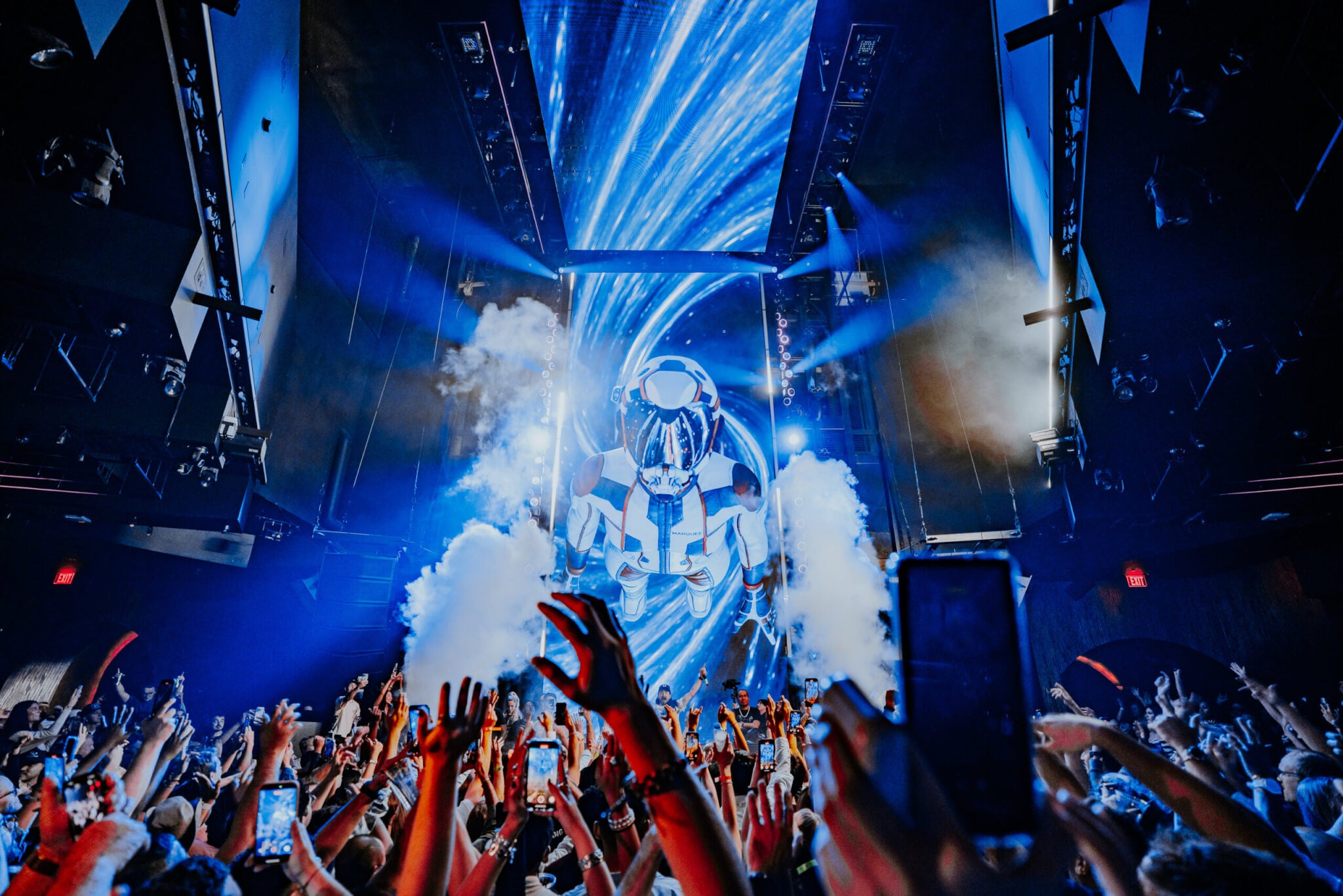 crowd at marquee nightclub with astronaut on the LED screen