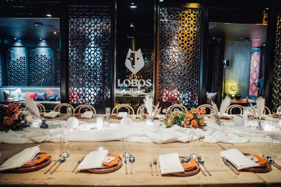 lobos tequila table scape with flowers and feathers