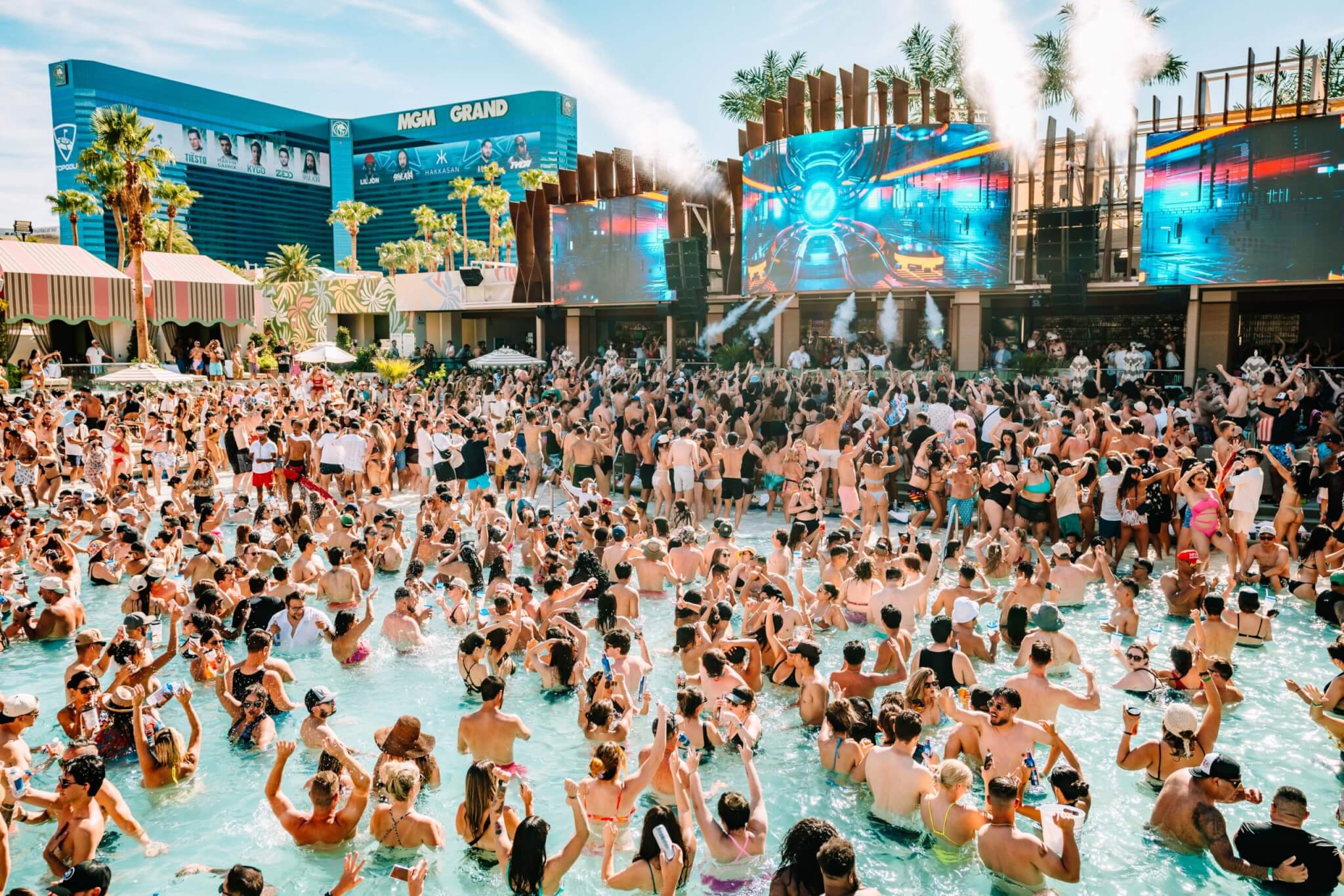 crowd dancing at palm tree beach club